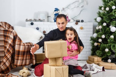 Mutlu genç baba ve kızı Noel ağacıyla evde. 