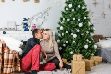 Güzel aşk iki halı şömine önünde oturan. Kadın ve adam Noel Kutlamaları