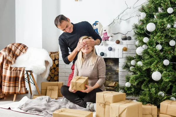 素敵な愛のカップルは 暖炉の前でじゅうたんの上に座っています 女と男のクリスマスを祝う — ストック写真