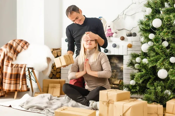 素敵な愛のカップルは 暖炉の前でじゅうたんの上に座っています 女と男のクリスマスを祝う — ストック写真