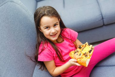 Evde büyük pizzalı küçük kız.
