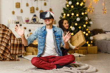 Baba ve kızı Noel ağacının yanındaki otururken Vr kulaklık kullanarak