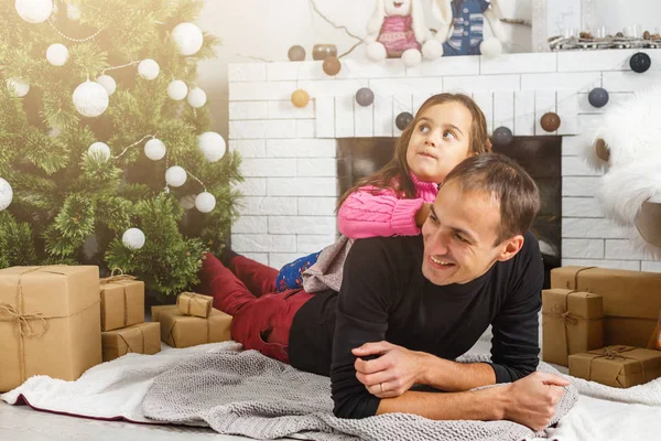 幸せな若い父親と娘がクリスマスツリーを持って家にいます — ストック写真