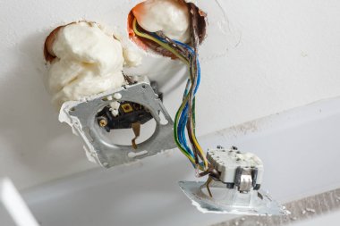 İki yuva kapağı olmadan yükleme sırasında. Onarım sırasında. Teller açın. Avrupa soket beyaz arka plan üzerinde izole kapak olmadan. Elektrik yuva profesyonel kurulum