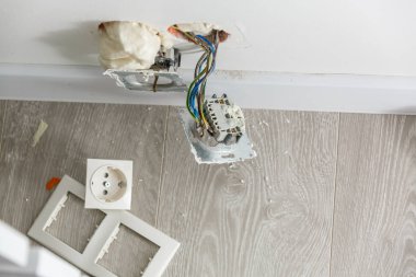 İki yuva kapağı olmadan yükleme sırasında. Onarım sırasında. Teller açın. Avrupa soket beyaz arka plan üzerinde izole kapak olmadan. Elektrik yuva profesyonel kurulum