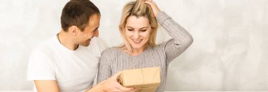 Onlar evde kanepede oturuyorsun yakışıklı genç bir hediye güzel kız arkadaşına veriyor