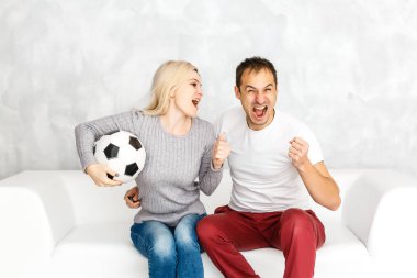 Evde futbol izleyen genç bir çift.