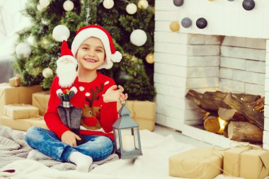 Küçük çocuk Noel ağacının yanında.