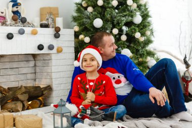 Gülümseyen baba ve oğlu evde Noel tatilinin tadını çıkarıyorlar.