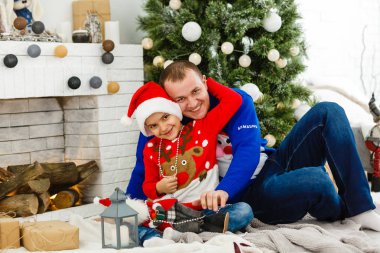 Gülümseyen baba ve oğlu evde Noel tatilinin tadını çıkarıyorlar.