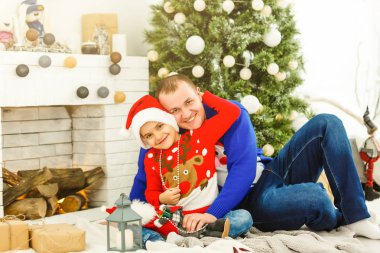 Gülümseyen baba ve oğlu evde Noel tatilinin tadını çıkarıyorlar.