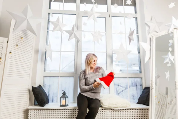Genç Bir Kadın Noel Süslemeli Bir Odada Pencerede Oturuyor — Stok fotoğraf