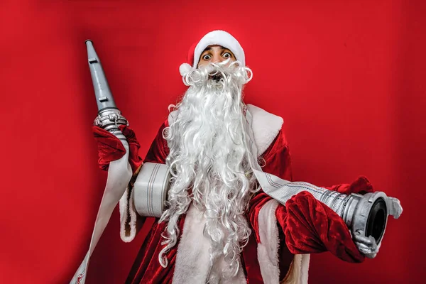 Christmas man in santa clothes with fire Hose standing against isolated white background — Stock Photo, Image