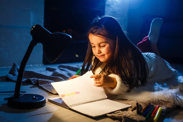 Uma Menina Bonita Escrevendo Caderno Chão Sob Lâmpada — Fotografia de Stock