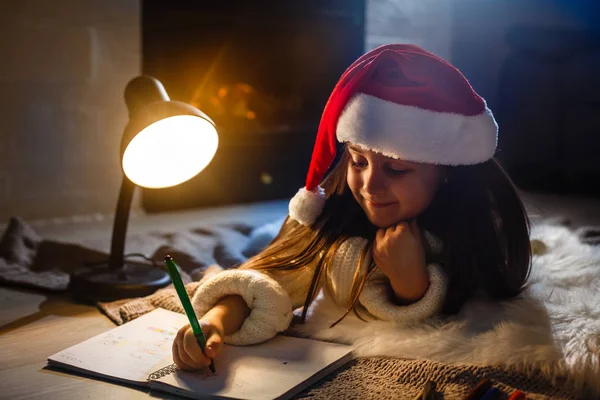 Cute little girl writing a letter to Santa