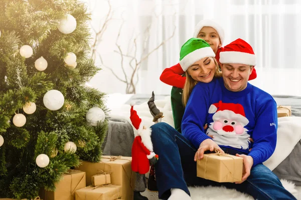 매력적인 가족 크리스마스 트리 근처에 앉아 — 스톡 사진