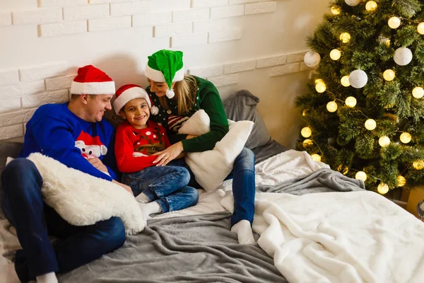 La charmante famille assise près du sapin de Noël — Photo