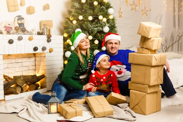 Die charmante Familie sitzt am Weihnachtsbaum — Stockfoto