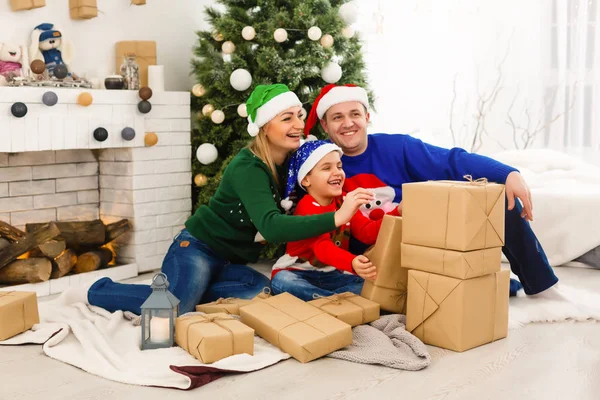 Die charmante Familie sitzt am Weihnachtsbaum — Stockfoto