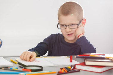 Zeki, neşeli, mutlu, küçük, çocuk, okullu çocuk problemleri ve dersleri çözer.  