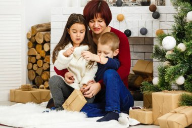Genç anne ve iki küçük kızı Noel arifesinde sıcak, karanlık bir oturma odasında ellerinde mumlarla şöminenin başında oturuyorlar. 