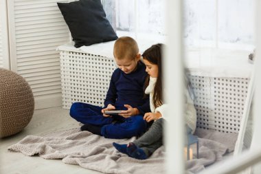 Erkek ve kız telefon kullanıyor, oyun oynuyorlar. 