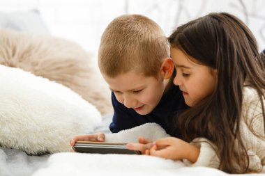 Erkek ve kız telefon kullanıyor, oyun oynuyorlar. 