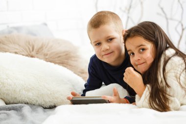 Erkek ve kız telefon kullanıyor, oyun oynuyorlar. 