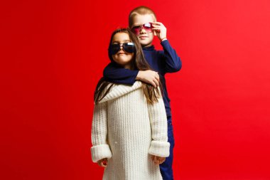 İki mutlu komik çocuk bir arada ve sarılıyorlar, kırmızı ışıkta izole olmuşlar. 