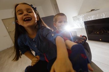 Kot pantolonlu tatlı küçük kız modern rahat sandalyesine oturmuş beyaz oturma odasında dinleniyor. Çocukluk, okul çocukları, gençlik, rahatlama konsepti 