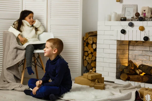 暖炉でクリスマスの前夜に家族 ギフトボックス付きクリスマスツリーの下の子供たち 伝統的な暖炉のある装飾されたリビングルーム 家で居心地の良い暖かい冬の夜 — ストック写真
