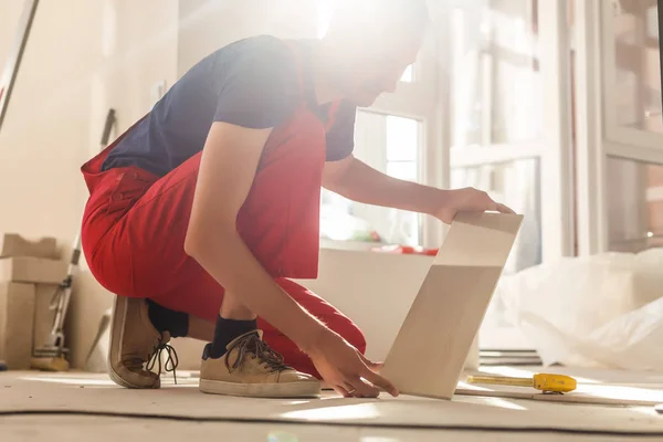 Meister Trägt Arbeitskleidung Überprüft Den Horizont Der Verlegung Von Fliesen — Stockfoto