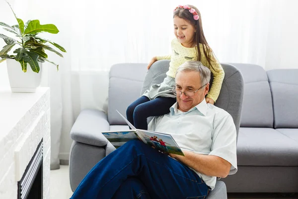 Grandfather and granddaughter on sofa at home. Grandpa and child — ストック写真