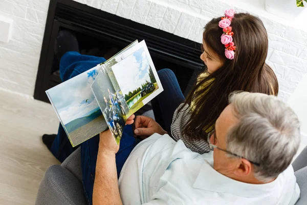 Wnuczka i dziadek oglądają razem zdjęcia w mgnieniu oka — Zdjęcie stockowe