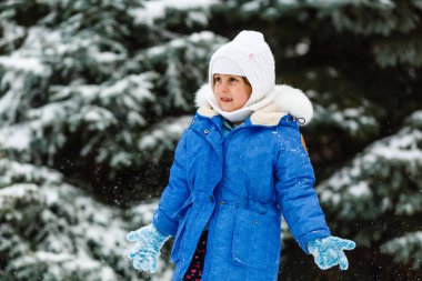 Küçük kız dışarıda kartopu yapıyor.