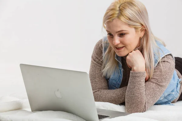 Glückliches Mädchen Liegt Mit Laptop Der Nähe Einer Lichtwand Auf — Stockfoto