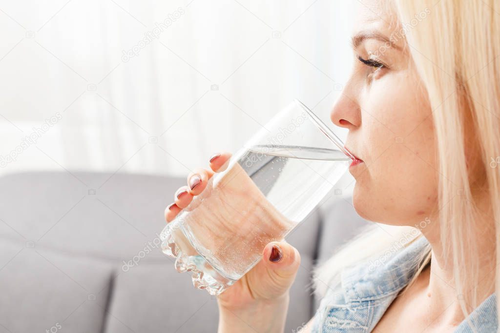 Young woman drinking pills and water