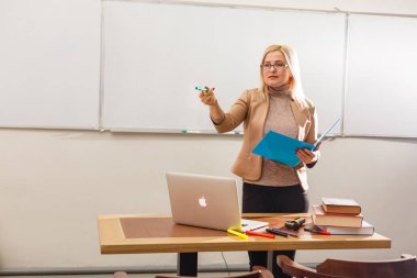 Sınıfta dizüstü bilgisayarı olan güzel bir öğretmen.