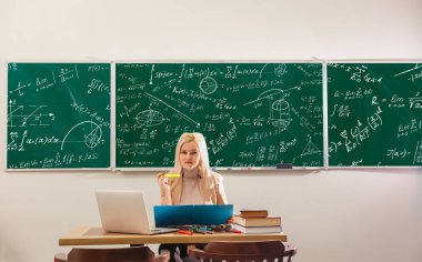 Öğretmen yetenekli lideri, uygun öğrenme stili, Modern öğretmen hipster yazma matematik formülüyle büyük yazı tahtası üzerinde bazı öğrenciler iyi dinleyerek öğrenmek onun yöntemi eğitim için öğrenci görünüyor,