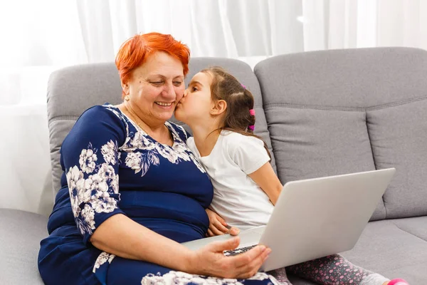 Nonna utilizzando computer portatile e calcolatrice con nipote — Foto Stock