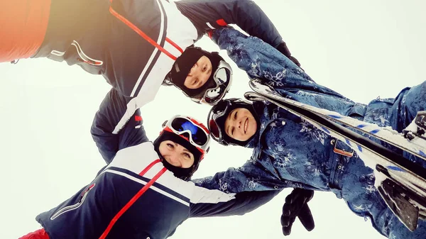 Група щасливих лижників і сноубордистів стоїть в колі і — стокове фото