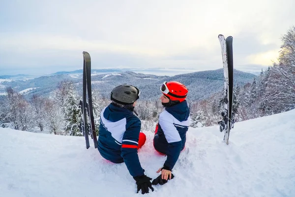 Skifahrer entspannen sich bei sonnigem Winterwetter mit blauem Himmel im Schnee — Stockfoto