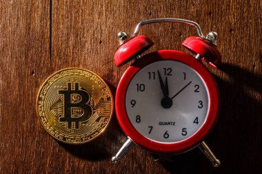 Ahşap zemin üzerinde çalar saat ve bitcoin