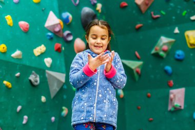 Boş zamanlarında duvarlara tırmanan küçük bir kız. 