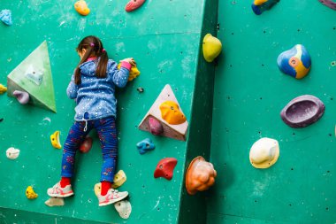 Boş zamanlarında duvarlara tırmanan küçük bir kız. 