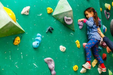 Boş zamanlarında duvarlara tırmanan küçük bir kız. 