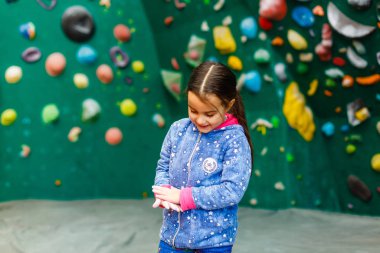 Boş zamanlarında duvarlara tırmanan küçük bir kız. 