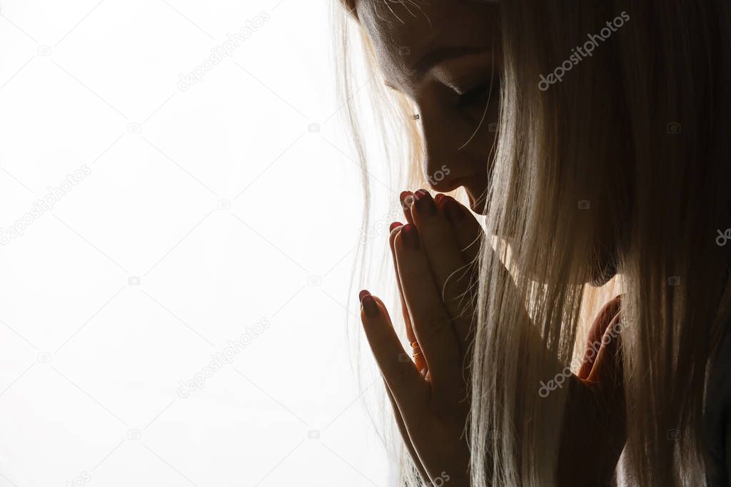 Beautiful redhead freckled young teen girl prays. Close up portrait of a female praying