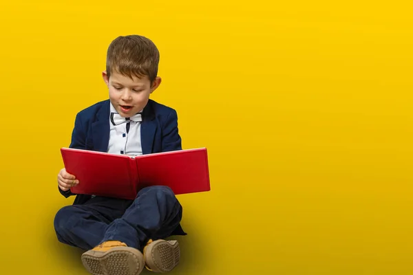 Büyük Bir Kitap Okuyan Küçük Bir Çocuk Sarı Arkaplanda Izole — Stok fotoğraf