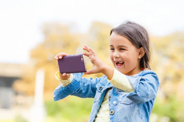 Video streaming. Adorable child learning new technology. Little girl using mobile phone. Small girl child with smartphone. Cute mobile phone technology user. Watching video on mobile device.
